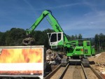 A trailing cable supplies electric current to the SENNEBOGEN 821 as it moves along a ramp handling waste material at the Remo Recycling AG facility. The specially-designed industrial maXCab features bullet-proof armored glass.